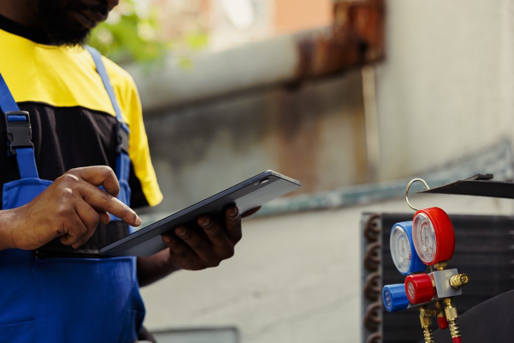 Why Diesel Fuel Testing Matters: Key Benefits for Industrial Operations 2 african american electrician doing leak checks other necessary repairs prevent major breakdowns licensed serviceman verifying air conditioner writing findings clipboard